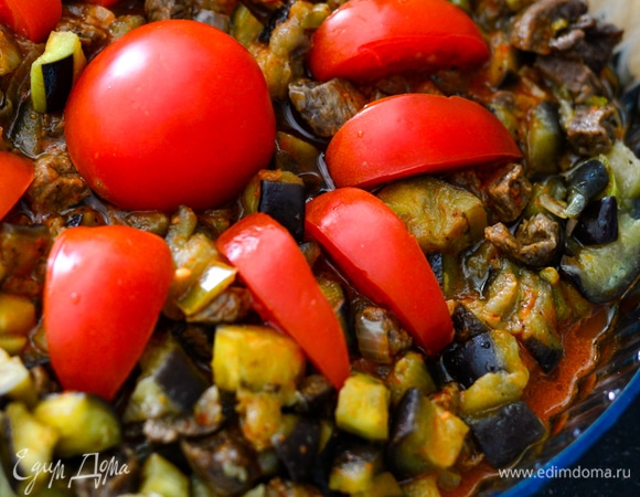 Соедините баклажаны с мясом, залейте соусом и украсьте свежими помидорами. Отправьте в разогретую до 220°C духовку на 20–30 минут.