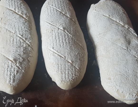 Багеты аккуратно выложить на противень, сделать надрезы. Выпекать 10 минут при 240°C, потом понизить до 200°C и выпекать еще 20 минут.