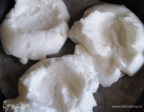 Форму или противень застелить пергаментом. Столовой ложкой выложить белки. В середине каждого сделать углубление.