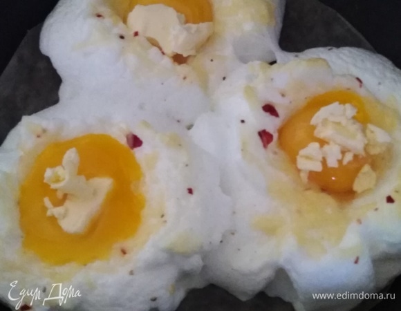 На каждое яйцо положить кусочек сливочного масла. Поставить обратно в духовку на 10 минут.