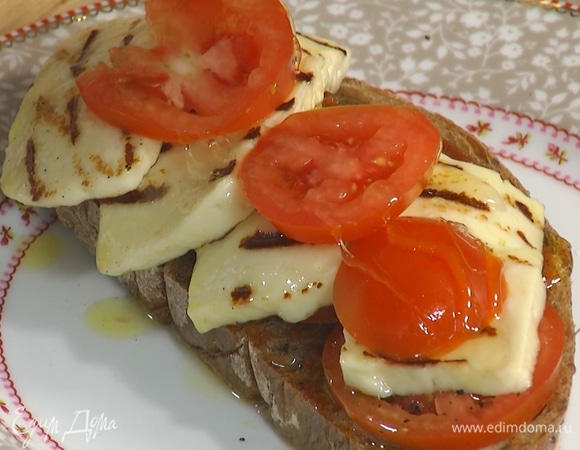 Один кусок обжаренного хлеба смазать пастой харисса, выложить на него половину помидоров, поперчить, затем добавить обжаренный халуми и оставшиеся помидоры, полить все медом.