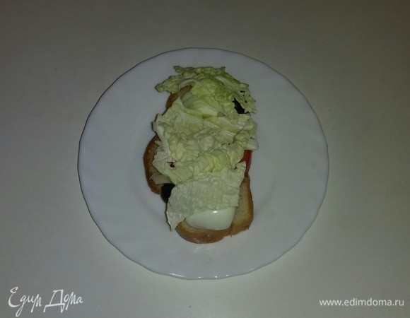 Затем выкладываем на каждый кусочек белого хлеба слой нарезанных листьев китайского салата.