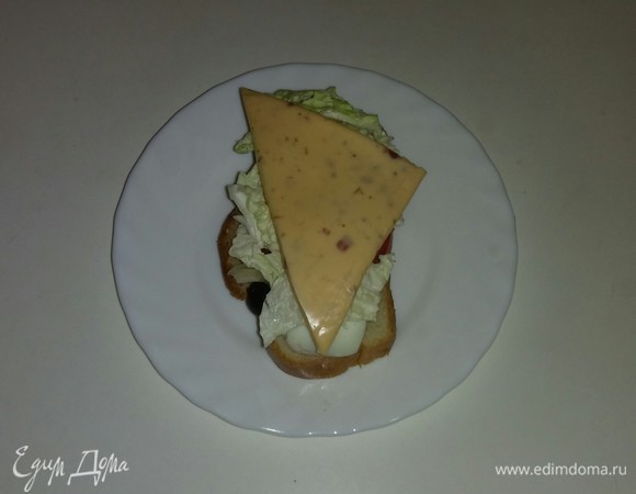 На каждый кусочек хлеба кладем треугольный кусочек сыра. Выкладываем все бутерброды на противень и ставим его в разогретую до 170°C духовку на 7–8 минут (время выпечки зависит от вашей духовки). Бутерброды готовы. Приятного аппетита!
