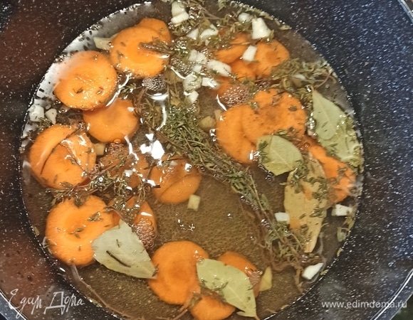 В отдельную кастрюлю налить вино с бульоном (либо просто бульон, тогда около 1 л 100 мл). Если нет мясного бульона, развести 1–2 кубика в горячей воде. Добавить нарезанную кольцами морковь, нарезанный кубиками чеснок, тимьян и лавровый лист. Довести до кипения, посолить, поперчить по вкусу. Выключить.