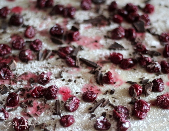 Смазываем растительным маслом готовое тесто и равномерно раскладываем вишню. Если берете замороженную вишню, обязательно следует ее разморозить и откинуть на сито минимум на 30 минут, чтобы ушла лишняя жидкость. Посыпаем сверху крахмалом и шоколадом. Края теста оставляем без начинки на ширину около 10 см.