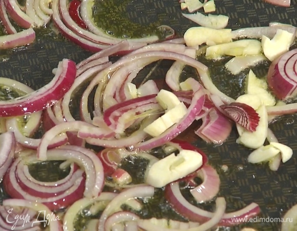 Разогреть в большой сковороде оливковое масло, обжарить нарезанный лук и чеснок. 