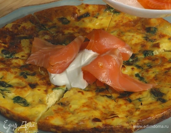 Готовую яичницу разрезать на части, украсить сметаной и ломтиками копченой семги.