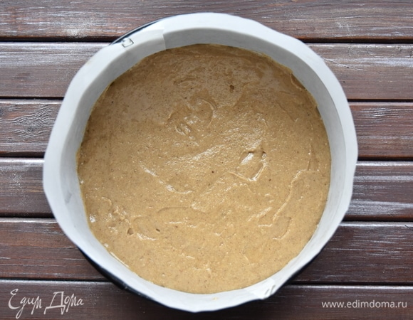 Форму для выпечки выстелить пергаментом, выложить тесто и разровнять.