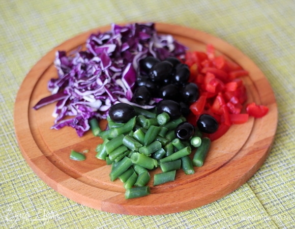 Капусту режем мелкой соломкой, замороженную стручковую фасоль моем, мелко режем, также мелко режем болгарский перец. Маслины можно разрезать на половинки или четвертинки, а можно оставить целыми — на ваш вкус.