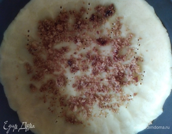 Духовку разогреть до 180°C. Достать форму, наколоть тесто вилкой, посыпать половиной крошки и поставить на 10 минут в разогретую духовку.