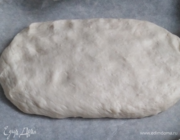 Выложить на противень, застеленный пергаментом. Придать овальную форму. Толщина лепешки — 1,5–2 см. Накрыть полотенцем. Дать подняться в течение 30 минут.