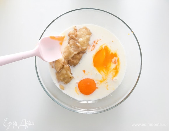 В отдельную миску влить молоко, добавить 2 желтка, пюре банана, соль и перемешать все миксером.