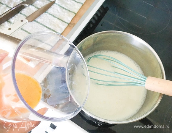 Для крема высыпать в сотейник сахар, крахмал и влить молоко, поставить на средний огонь, перемешать и подогреть смесь, не переставая перемешивать.