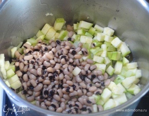 В кастрюле с толстым дном разогрейте оливковое масло и слегка обжарьте на нем сельдерей. Затем добавьте кабачки, чеснок и отваренную фасоль с бульоном, в котором она варилась.