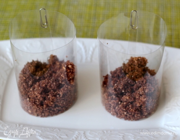 В основы для десерта насыпаем крошку. В качестве основы для десертов или порционных салатов я использую ацетатную пленку (продается в магазинах для кондитеров), ее удобно отрезать нужной длины, скрепить скрепкой и потом снимать. Также хорошо видно слои, и можно сделать ровненько и аккуратно.