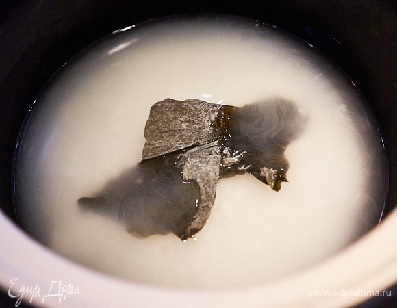 Замачиваем рис. При таком способе приготовления воды надо брать чуть больше риса — на 100 г риса 110–120 мл воды. Рис не промываем, засыпаем в донабэ и заливаем соответствующим количеством воды. У меня сверху лежит водоросль комбустиологам. Продается в любом азиатском магазине. Нам необходим небольшой кусочек — 5 х 5 см. Без водорослей совершенно спокойно можно обойтись, но они дают совершенно неуловимый аромат. Закрываем крышку и оставляем на 20 минут, больше крышку не открываем до самого конца.