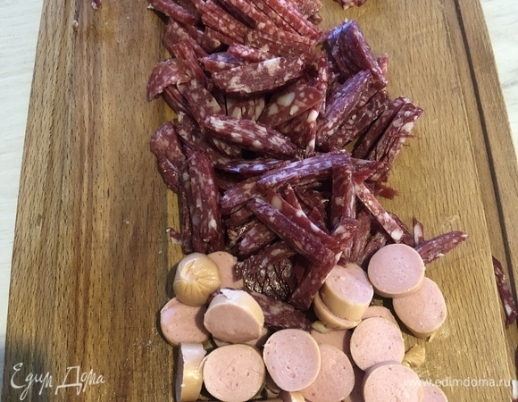 Нарезаем колбасу, сосиски, все мясное, что было в холодильнике (у меня — три вида колбасы и пару сосисок). Нарезаем так, кому как вкусно. Я нарезал колбасу соломкой, сосиски — кружочком.