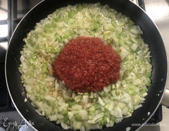 Разогреваем оливковое масло, отправляем овощи на сковороду. После того как лук станет прозрачным, добавляем томатную пасту, солим, перчим, кладем сахар. 