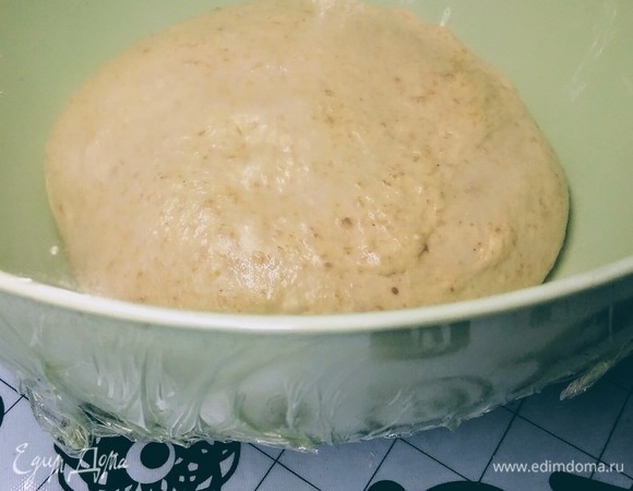 Смазать маслом руки и достать тесто из тестомешалки. Уложить в миску, накрыть пищевой пленкой в натяжку и отправить на расстойку на 1–1,5 часа в духовку или в другое теплое место.