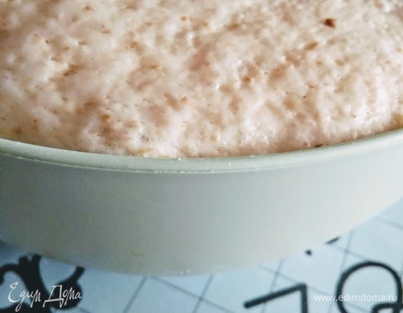 Когда тесто подойдет, выложить его на стол (без муки), расправить руками в прямоугольник. Сложить в конверт: загнуть края с боков вовнутрь, затем — верхний и нижний края. Соединить части, перевернуть и уложить в форму.