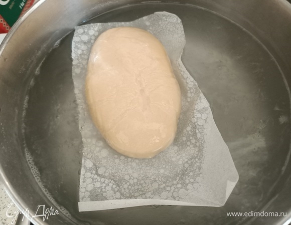В кипящую воду добавить соду. Опустить тесто вместе с бумагой. Варить 30 секунд с каждой стороны.