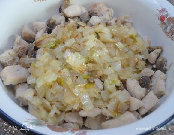 И в этой же сковороде обжариваем до золотистого цвета мелко нарезанную луковицу с нарубленным чесноком. Выкладываем лук к грибам с мясом.