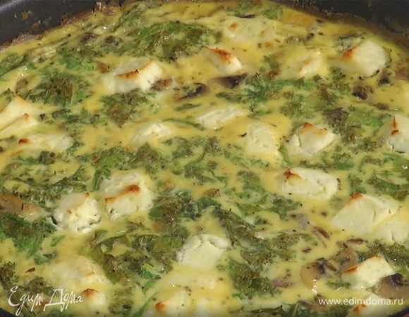 Овощи в сковороде залить яичной смесью, сверху разложить фету и запекать в разогретой духовке 10 минут.