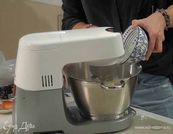 Белки поместить в чашу комбайна и взбить на большой скорости в крепкую пену, затем, не выключая комбайна, небольшими порциями ввести 150 г сахарной пудры и взбивать белки еще минимум 10 минут.