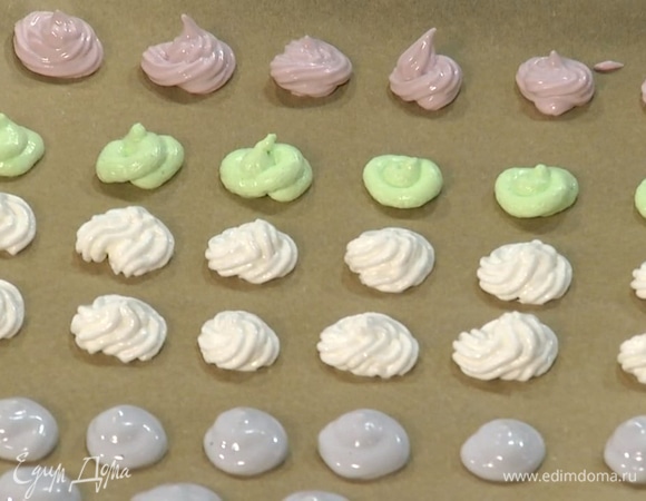 Застелить противень бумагой для выпечки, выдавить маленькие меренги из взбитых белков на некотором расстоянии друг от друга и выпекать в разогретой духовке 20 минут.