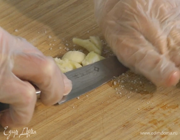 Чеснок почистить и раздавить плоской стороной ножа, затем, вынув горькую сердцевину, слегка посолить и выложить в глубокую миску.