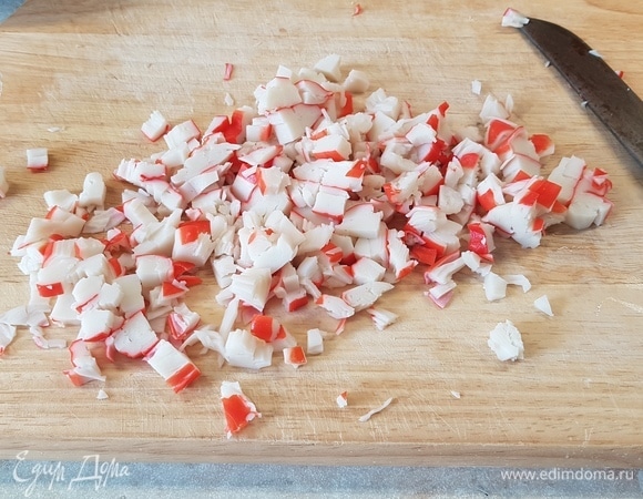 Крабовые палочки (или крабовое мясо) нарезать кубиком.