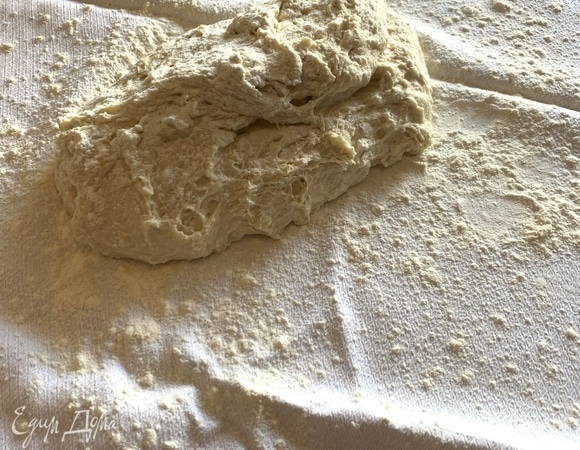 Через 12 часов переложить поднявшееся тесто на чистое кухонное полотенце, посыпанное мукой, и укрыть его со всех сторон. Оставить его так на 30 минут.