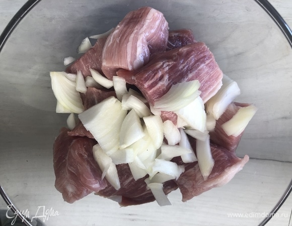 Мясо режем на средние куски: добавляем лук, солим, перчим.