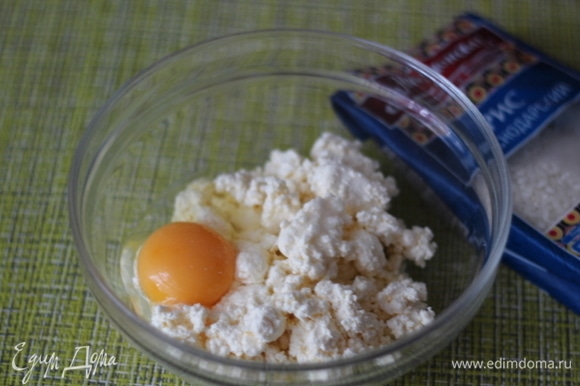 В творог добавляем яйцо, ванилин и хорошо разминаем ложкой до однородной массы. Изюм запарить кипятком, слить воду и обсушить салфеткой.