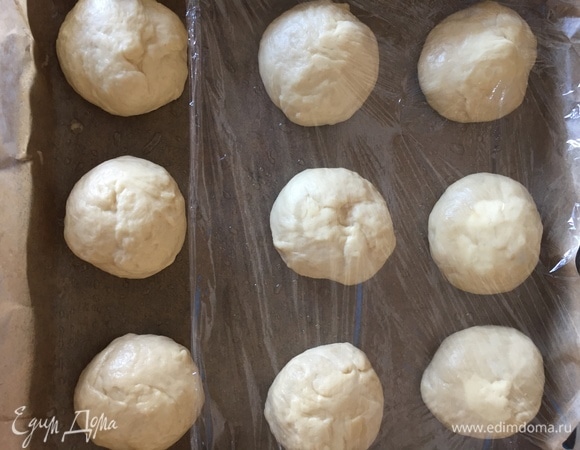 Через час достаем наше тесто, оно поднялось в 2–3 раза. Делим на равные части (я делила на 9 частей, у меня получились по 79 г). Накрываем пищевой пленкой или полотенцем и оставляем подходить на 15 минут.