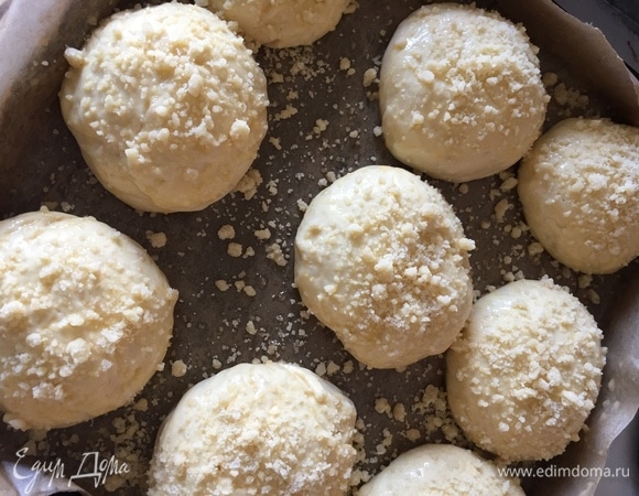 Булочки подошли, смазываем желтком и посыпаем нашей крошкой. Отправляем в духовку выпекаться при 180°C на 25–30 минут.