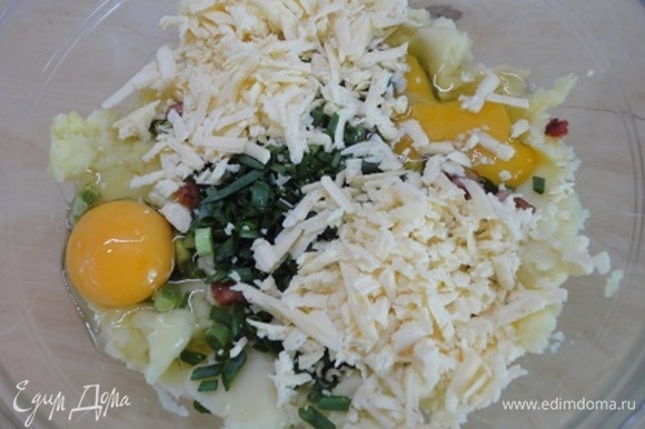 К картофелю с беконом добавить рубленые перья зеленого лука, яйца, тертый сыр, посолить по вкусу. Добавить тушеную капусту и перемешать.