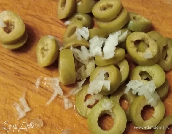 Оливки нарезать кольцами. Чеснок натереть или пропустить через пресс.