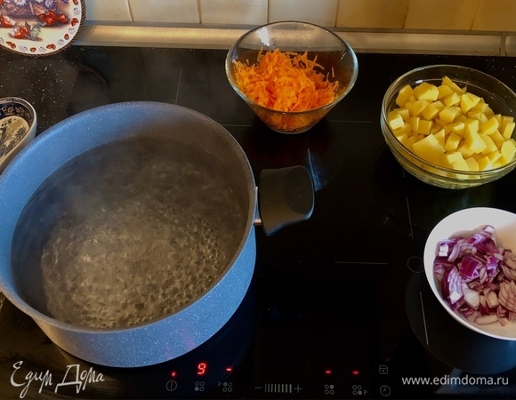 Добавить картофель, морковь и лук в кипящую воду.