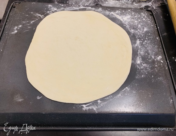 Раскатываем тесто на пиццу так, чтобы серединка была тоньше краев, то есть от середины к краям, но не сильно на них надавливаем. Оставшиеся кусочки покрываем пищевой пленкой, чтобы не заветривались, и пока занимаемся одной пиццей, остальное тесто продолжает подниматься уже на столе. Неиспользованные «шарики» кладем по одному в фасовочные пакетики, припыленные мукой, и убираем в холодильник. Я и в морозильной камере храню уже раскатанное тесто — тоже все прекрасно затем выпекается.