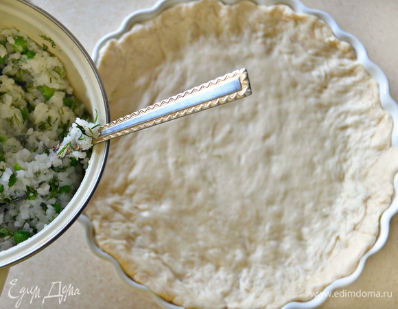 Достаточно большую форму (у меня форма диаметром 28см) для выпечки смажьте растительным маслом и выложите слоеное тесто, формируя бортики (предварительно тесто, конечно, нужно будет разморозить).