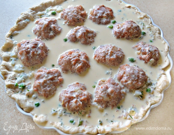 Постепенно влейте яично-молочную смесь. С помощью вилки можно «прорыхлить» немного начинку, чтобы помочь заливке равномерно распределиться. Аккуратно поместите форму в духовой шкаф, нагретый до 180°C. Запекайте пирог не менее 1 часа до полного застывания начинки. Если в процессе приготовления тесто уже подрумянилось, а начинка еще не пропеклась, то прикройте пирог фольгой и готовьте до полного застывания (температуру запекания можно слегка уменьшить). В любом случае ориентируйтесь по своей духовке.