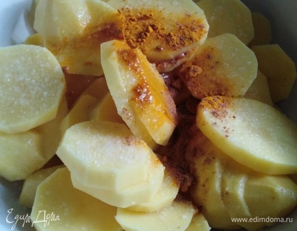 Картофель почистить, нарезать кружочками толщиной 0,5 см. Добавить соль, мускатный орех, куркуму, растительное масло. Перемешать.