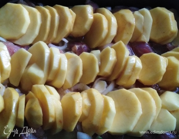 В форму для запекания выложить мясо с луком, сверху уложить картофель. Накрыть форму фольгой. Поставить в духовку на 40 минут при 190°C.