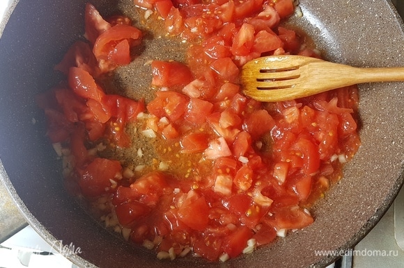 С помидоров снять кожицу. Нарезать их квадратиками и отправить в сковороду к чесноку.