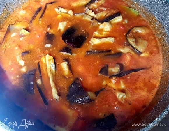 Выложить баклажаны к помидорам, накрыть крышкой и на медленном огне потушить 5–7 минут. Подавать, посыпав зеленью.