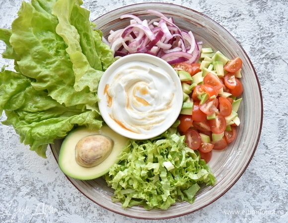 В качестве свежего наполнения для тако подготовить овощи. Нарезать листья салата. Томаты черри смешать с авокадо и сбрызнуть соком лайма, посолить приправить перцем чили по вкусу. Красный лук замариновать в смеси винного уксуса. Для смягчения остроты начинки смешать натуральный йогурт с паприкой и несколькими каплями табаско.