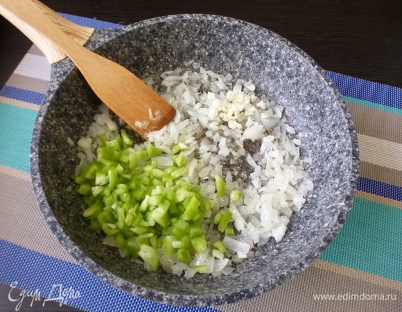 Добавить измельченный чеснок, через минуту — нарезанный кубиком сладкий зеленый перец и вино. Готовить 2–3 минуты.