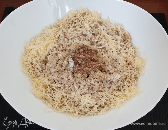 В емкость с рыбой и креветками добавим киноа, сыр, дижонскую горчицу, вольем сливки, добавим по вкусу соль и перемешаем.