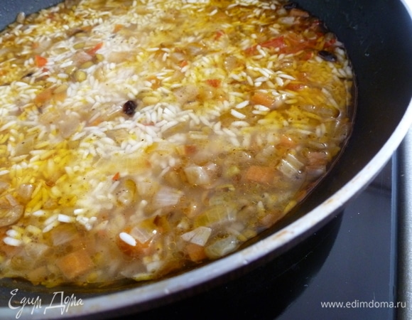 Добавить воды выше риса на 1 см. Воткнуть головку чеснока, посолить, закрыть крышкой и готовить еще 25–30 минут на маленьком огне.